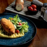 Kotlet schabowy z puree i sałatką, idealny do wyśmienitej wódki wyborowej.