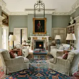 Elegant living room with fireplace, portraits, and plush seating, showcasing the expertise of home design consultants.