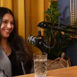 Uśmiechnięta studentka administracji podczas nagrania podcastu.