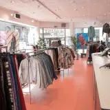 En ljus second hand-butik med kläder på galgar och skyltdockor. Kanske hittar du dina nästa humana second hand lediga jobb här!