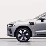 Srebrny samochód typu PHEV jest ładowany. To połączenie silnika spalinowego i elektrycznego, co oznacza, że możesz jeździć na prądzie lub paliwie.