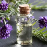 Huile de lavande dans un flacon, entourée de fleurs de lavande. Idéal pour apprendre comment faire de l'huile de lavande.