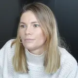 Maja Bohosiewicz w swetrze z golfem i złotymi kolczykami, zamyślona.