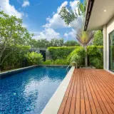 Piscine extérieure avec terrasse en bois, entourée de verdure luxuriante. Un espace de détente qui respecte l'esprit de l'article R.111-19 du code de l'urbanisme.