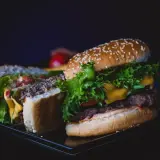 Pyszny kurczak burger mc, przekrojony na pół, z soczystą sałatą, serem i pomidorami.