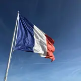 Francuska flaga powiewa na wietrze. Chciałbym móc mówić po francusku, tak jak te czasowniki modalne francuski.