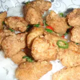 Chrupiący kurczak po koreańsku yangnyeom z podwójnie smażoną panierką ze skrobi, podany na ryżu z papryczkami chili.