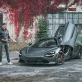 Mężczyzna prezentuje szarego McLarena 720S z otwartymi drzwiami. Zastanawiasz się nad mclaren 720s cena?
