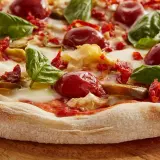 Pyszna pizza z pomidorkami, bazylią i ciągnącym się **serem mozzarella**. Idealna na letni wieczór.