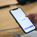 Dłoń trzyma iPhone'a, na ekranie którego wyświetla się komunikat "Face ID". Wygląda na to, że Face ID nie działa.