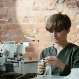 Krawcowa przygotowuje materiał, by pokazać, jak wszyć klin do spodni w kroku.