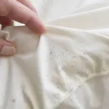 Szare plamy po praniu jak usunąć? Na białym materiale widać ciemne i żółtawe przebarwienia.
