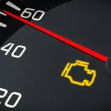 El tablero de un coche muestra el **luces cortas simbolo** del motor encendido, indicando un problema.