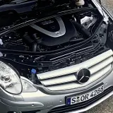 Motor de Mercedes Clase R, con capó abierto. Se aprecian componentes mecánicos y el logo de Mercedes. Posibles mercedes clase r problemas.