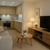 Salón y cocina integrados con muebles de madera clara. La iluminación cálida crea una atmósfera acogedora, mostrando la escala de temperatura de color ideal para el hogar.