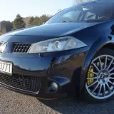Ciemnoniebieski Renault Megane 2 z żółtymi zaciskami hamulcowymi Brembo na alufelgach.