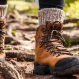 Brown leather hiking boots with thick socks, ready for the trail. Proper wanderschuhe pflegen ensures many adventures.