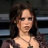 Jenna Ortega, znana z roli Wednesday, ma 160 cm wzrostu. Na zdjęciu ma ciemne włosy i krzyż na szyi.