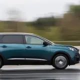 Turkusowy Peugeot 5008 2.0 HDI w ruchu, z rozmytym tłem.