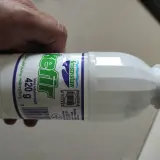 Butelka kefiru Krasnystaw 420g, z zieloną zakrętką, trzymana w dłoni.