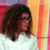 Aleksandra Pawlicka, z burzą kręconych włosów i okularami, opowiada o swoich dzieciach na tle kolorowego studia.