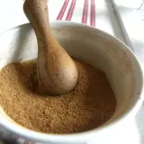En mortel med en trästövel fylld med egen pepparkakskrydda. Doften av jul sprider sig.