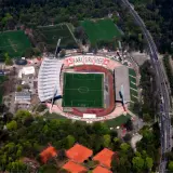 Stadion Karlsruher SC z lotu ptaka, z boiskiem, trybunami i otaczającym go lasem.