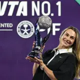 Uśmiechnięta tenisistka z pucharem po wygranym turnieju WTA.
