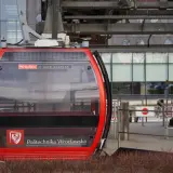 Czerwona kolejka linowa "Polinka" na trasie Wrocław - miasto spotkań, z widocznym herbem Politechniki Wrocławskiej.
