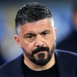 Gennaro Gattuso, zamyślony trener w granatowej marynarce, z charakterystyczną brodą i siwiejącymi włosami.