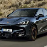 Ciemnoszary Cupra Tavascan jedzie po drodze. Sprawdź aktualną cupra tavascan cena i dowiedz się więcej o tym stylowym SUV-ie coupe.