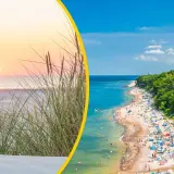 Zachód słońca nad morzem, plaża pełna ludzi i latarnia morska. W tle niebieska flaga, symbol czystej wody.