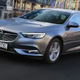 Szary Opel Insignia 2.0 CDTI w wersji kombi jedzie po miejskiej drodze.
