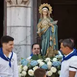 Procesión de la Virgen de la Guía, con hombres portando la imagen adornada con flores.