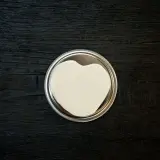Ein Herz aus weißer Farbe auf einem silbernen Deckel. So mischt man Weiß für ein romantisches Projekt.