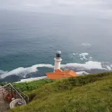 El faro del pescador en Santoña se alza vigilante sobre el mar Cantábrico, con espuma blanca adornando las olas.