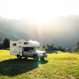 Camping-car dans un paysage montagneux ensoleillé, un endroit idéal pour le meilleur pays pour voyager en van.