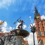 Fontanna Neptuna i Ratusz Głównego Miasta w Gdańsku Stare Miasto, pod błękitnym niebem.