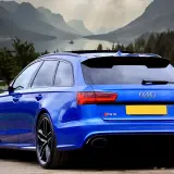 Niebieskie Audi RS6 z Niemiec, gotowe do rejestracji. Piękne góry i jezioro w tle.