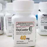 Butelki leku OxyContin, w tym jedna z dawką 40 mg, stoją na blacie.