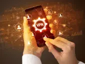 Dłonie trzymające smartfon z ikoną VPN i siecią połączeń użytkowników.