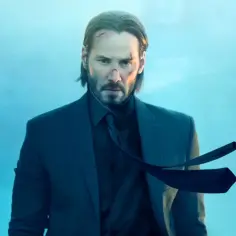 John Wick 5: Keanu Reeves w garniturze, z bliznami na twarzy, wpatruje się w dal.