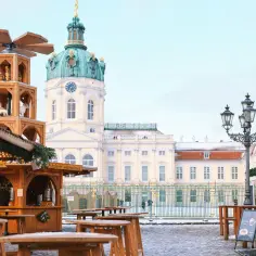 Drewniana piramida i stragany na jarmarku w Berlinie, w tle pałac Charlottenburg.