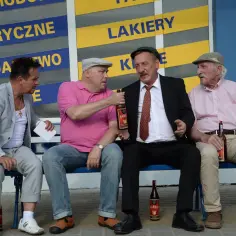 Czterech mężczyzn siedzi na ławce, pijąc mamrota.