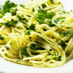 Pyszny makaron z pesto ze słoika, posypany świeżą natką pietruszki. Szybki i prosty obiad.