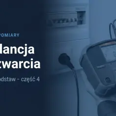 Pomiar impedancji pętli zwarcia za pomocą miernika. W tle widać rozdzielnicę elektryczną.