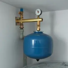 Niebieskie naczynie przeponowe z manometrem i zaworem podłączone do instalacji CO.