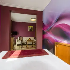 Pokój w hotelu Apollo Darłówko z kolorową tapetą i wygodnym łóżkiem.