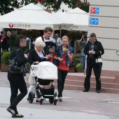 Tomasz Kuszczak z żoną i rodziną spacerują z wózkiem przy kawiarni "coffee".