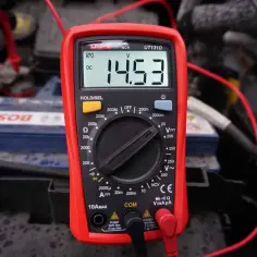 Multimetr pokazuje 14.53V DC, co jest pomocne, gdy zastanawiasz się, jak sprawdzić przekaźnik.